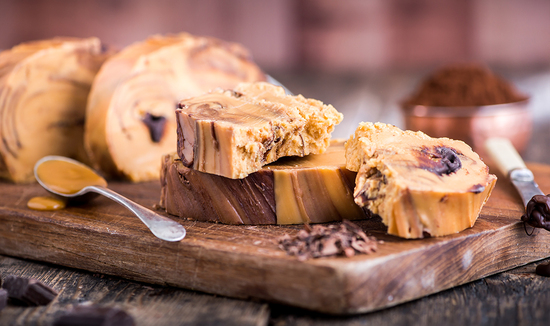 Indulge in Fudge Kitchen's handmade fudge, beautifully displayed on a wooden board, showcasing our artisan craftsmanship and quality ingredients.