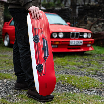 A car on a skateboard with a red BMW m3 behind it