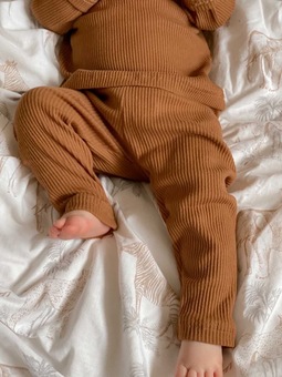 baby legs wearing rust coloured ribbed loungewear set