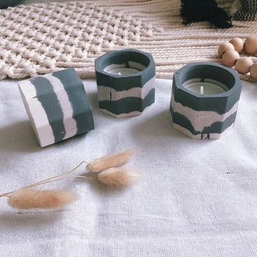 Black and sand coloured tealight holders, dried grass and wooden beads.