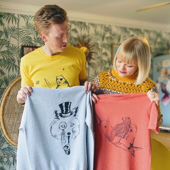 Lucy and Tom holding tshirts