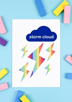 An art print on a blue background. The print has a blue cloud with lightening blots that are rainbow striped.