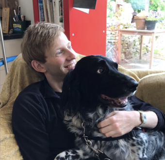 An image of Oliver Stockley with a very sweet dog
