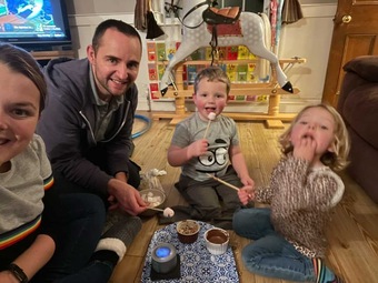 Photo of a family enjoying toasting marshmallows together in their lounge