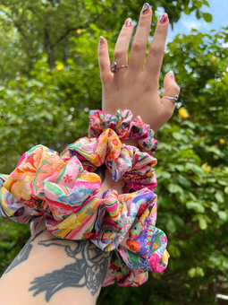 Stacked The Fruit Moth scrunchies on a wrist to show the size difference of the mini, midi and maxi scrunchies