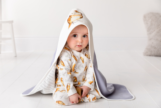 Baby modelling Olive Owl baby grow and wrap blanket by Catherine Rayner 