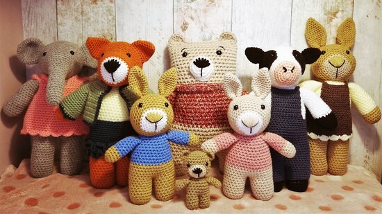Crochet Animals on wood backdrop. Bears, foxes, rabbits, elephant and cow