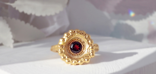Temple Ring. Gold ring with garnet gemstone.