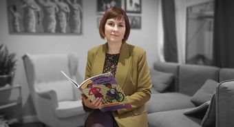 Picture of seller holding a book in her hands looking at the camera