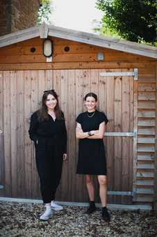 Two women stood outside shed