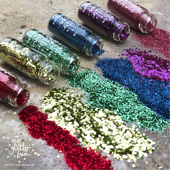 Spilled bottles of eco glitter in rainbow colours 
