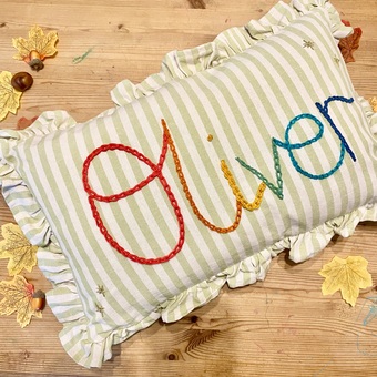 Hand embroidered bespoke rainbow cushion striped with drill ruffle trim. Boys name stars cushion, girls room, gift ideas children’s nursery 