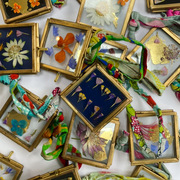 An assortment of mini pressed flower frames with gold leaf