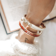 Our red enamel bangle with roman numeral date and the cream bangle embossed with intitials
