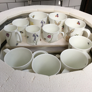 unloading a selection of mugs and teacups out of the kiln