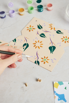 Hand painting a floral design on leather 