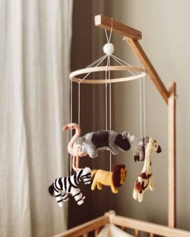 Handmade safari animal baby mobile. A scandi designed baby essential handmade in Nepal featuring 6 animals - a lion, zebra, elephant, giraffe, rhino & flamingo