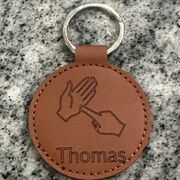 a vegan leather keyring engraved with british sign language