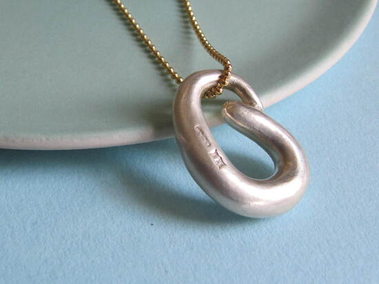 Handcrafted Infinity Silver Curl Pendant hung on gold chain