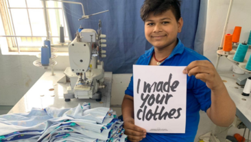 Image of a man holding a sign saying 'I made your clothes'