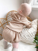 baby wearing beige knitted bloomer set