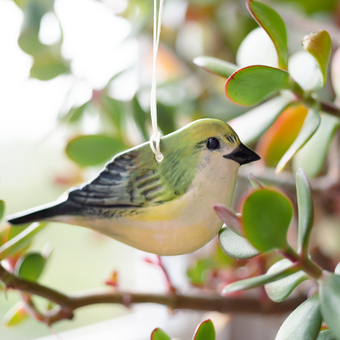 Greenfinch ornament hanging in a plant 