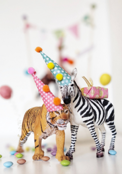 A party animal tiger and zebra both wearing party hats.