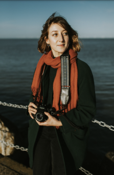 a portrait of a woman holding a camera