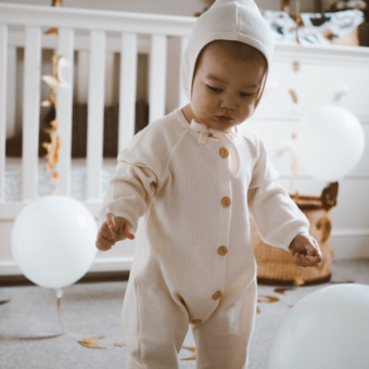 baby in cream waffle romper set with bonnet