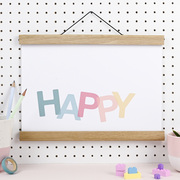 An art print hangs in a wooden poster hanger. The background is white and there are pastel letters spelling out the word HAPPY.