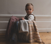 cute baby sat in basket with blankets