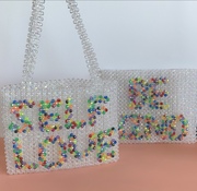 Iridescent beaded bags with rainbow words on the front, self love and be kind