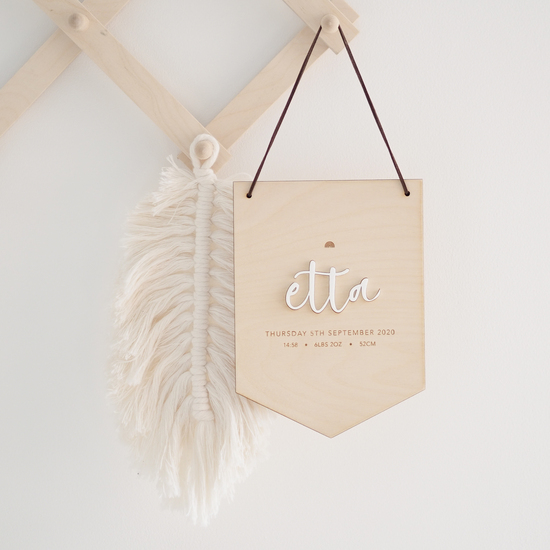 A wooden pennant shaped hanging sign with the name etta in white acrylic and birth stats engraved below