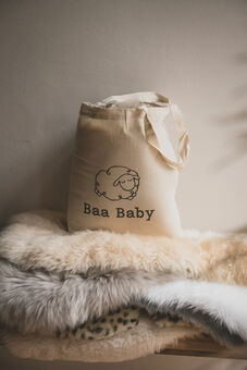 Baa Baby tote bag on a pile of fluffy sheepskin pram liners