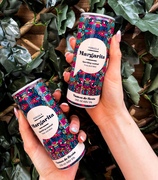 Two hands holding Pergola's Canned Margarita, ready to enjoy a refreshing cocktail.