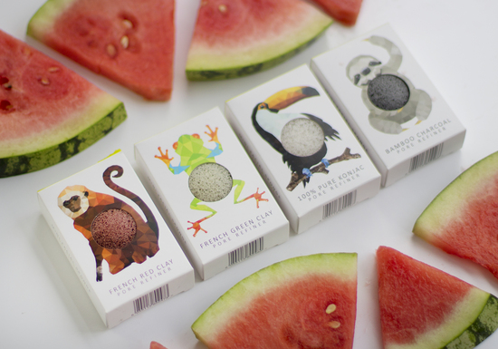 The Konjac Sponge Co Mini Rainforest Sponges, shown in their packaging with animal designs, featuring a Monkey, Frog, Toucan and a Sloth Shown with Watermelon