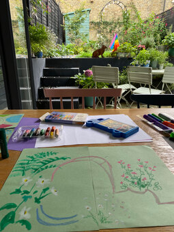 oil pastel drawing on table in front of small London garden view.