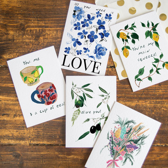 Flat lay image of colourful floral postcard designs