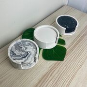 The photo shows three sets of coasters, one white, one grey and one black.