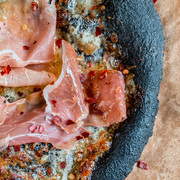 Black charcoal infused pizza dough base with gorgonzola, chilli and prosciutto topping
