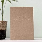 A kraft brown card with on your wedding day written in grade 1 braille.
