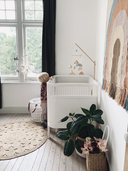 Handmade baby cloud mobile hung from a Scandinavian wooden mobile arm from Danish design house Konges Slojd. A beautiful baby nursery.