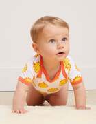 A baby crawling wearing a Toby Tiger Organic Gift Set - Sun Cloud Print