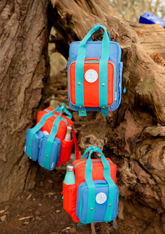 Three magnetic backpacks hanging in a tree