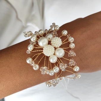 This beautifully handcrafted wedding corsage exudes timeless elegance and sophistication. It features an intricate arrangement of lustrous pearl beads and delic