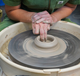 Detail of pots being handmade on the wheel