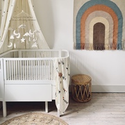 A beautiful Scandi style baby nursery featuring a Large Night Sky Baby Mobile with gold beads. Enveloped in an off-white organic cotton daisy print bed canopy