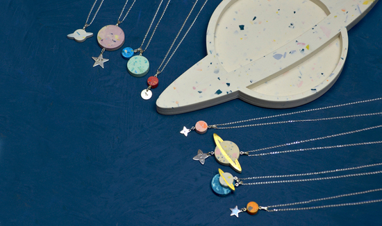 Saturn shaped trinket dish with necklaces surrounding it inspired by the planets