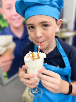 Connor enjoying some gelato ice cream in his chefs hat and apron