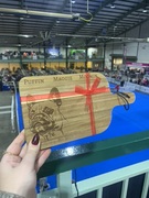 A personalised small chopping board engraved with a French Bulldog design and tied with a bow. 